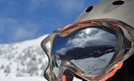 24748175 - alpine winter landscape with a ski slope is reflected in a ski mask